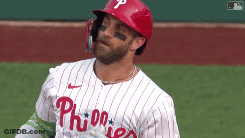 A Phillies Baseball Player Wearing A Red Helmet And A White Striped Jersey GIF