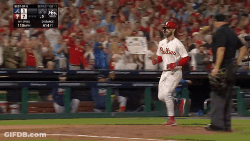 A Phillies Player Is Running Towards Home Plate During A Baseball Game GIF