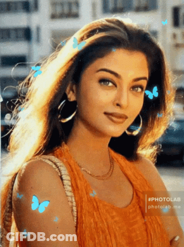 A Photo Of A Woman With Blue Butterflies Flying Around Her GIF