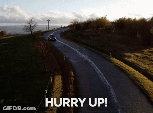 A Picture Of A Car Driving Down A Road With The Words Hurry Up Above It GIF