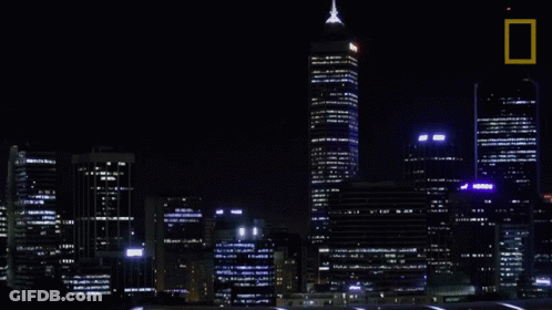 A Picture Of A City At Night With A National Geographic Logo GIF