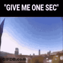 A Picture Of A City With The Words " Give Me One Sec " GIF