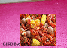 A Picture Of A Crawfish Boil With Corn And Potatoes GIF