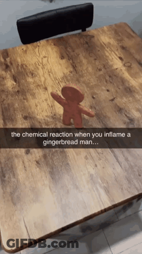 A Picture Of A Gingerbread Man On A Wooden Table GIF