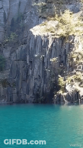 A Picture Of A Lake With A Cliff In The Background And The Words Viralheg GIF