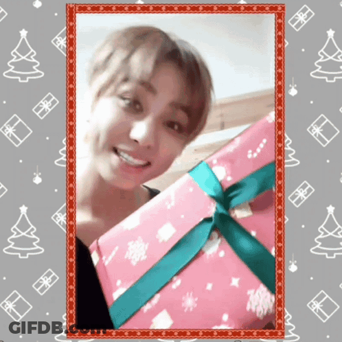 A Picture Of A Man Holding A Pink Gift Box With A Green Ribbon GIF