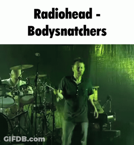 A Picture Of A Man On Stage With The Words Radiohead Bodysnatchers GIF