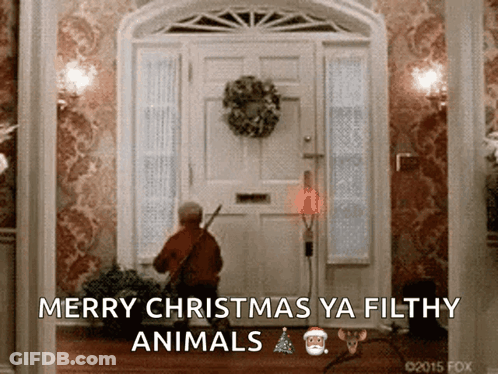 A Picture Of A Man Standing In Front Of A Door With The Words Merry Christmas Ya Filthy Animals On It GIF