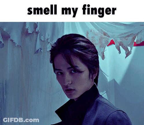 A Picture Of A Man With The Words " Smell My Finger " Above Him GIF
