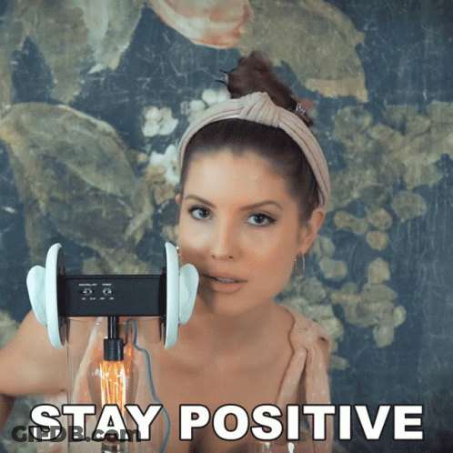 A Picture Of A Woman With Ear Buds And The Words Stay Positive GIF