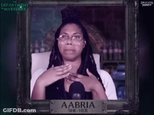 A Picture Of A Woman With Glasses And A Sign That Says Aabri She / Her GIF