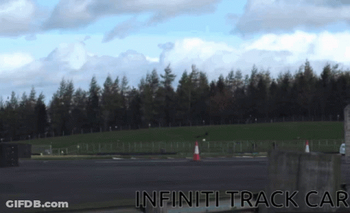 A Picture Of An Infiniti Track Car With A Forest In The Background GIF