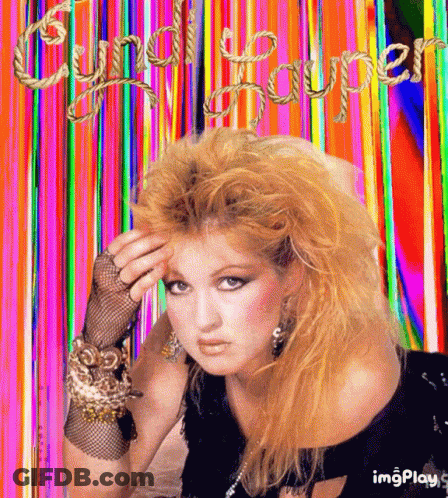 A Picture Of Cyndi Lauper With A Rainbow Background GIF