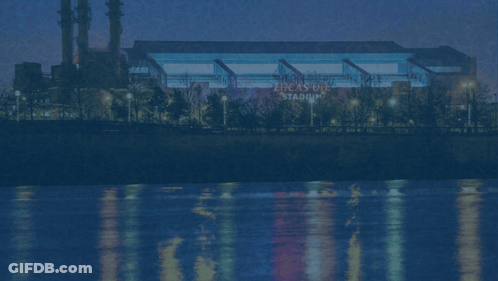 A Picture Of Lucas Oil Stadium With A River In The Background GIF