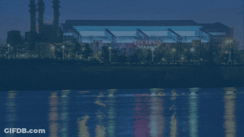 A Picture Of The Indianapolis Colts Stadium With A River In The Background GIF