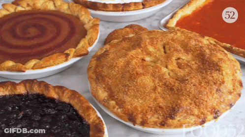 A Pie With The Number 52 On It Sits On A Table Next To Other Pies GIF