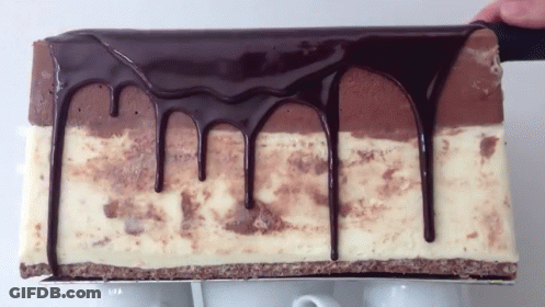 A Piece Of Cake With Chocolate Dripping Down The Sides GIF