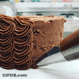 A Piece Of Chocolate Cake Is Being Frosted By A Piping Nozzle GIF