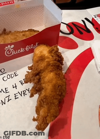 A Piece Of Fried Chicken Sits On A Table Next To A Chick Fil A Box GIF