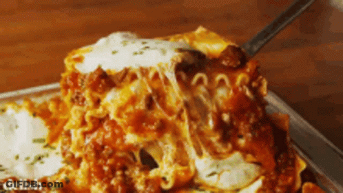 A Piece Of Lasagna Is Being Eaten With A Fork GIF