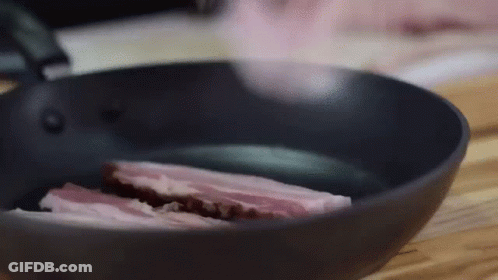 A Piece Of Meat Is Being Cooked In A Frying Pan GIF