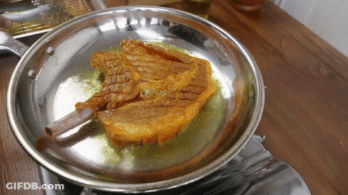 A Piece Of Meat Is Being Cooked In A Pan On A Stove GIF