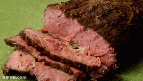 A Piece Of Meat That Has Been Sliced On A Cutting Board GIF