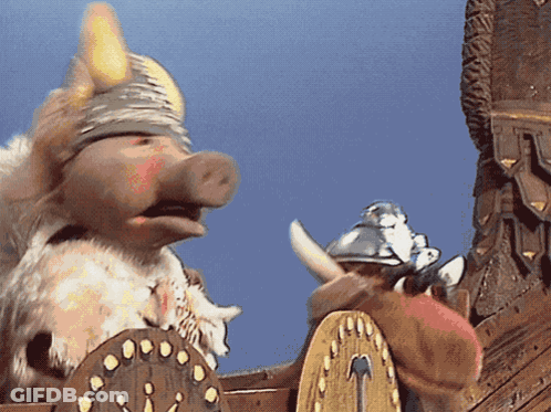 A Pig Wearing A Viking Helmet Is Standing Next To A Shield GIF