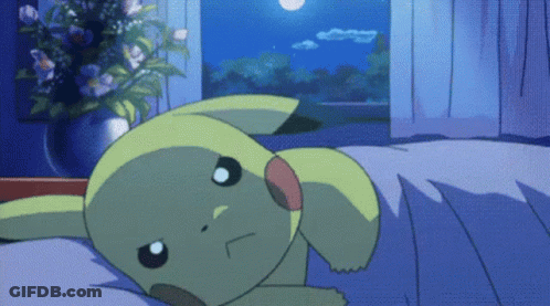 A Pikachu Laying On A Bed With A Vase Of Flowers Behind It GIF