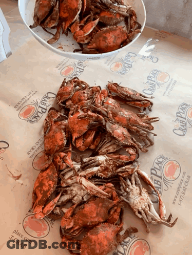 A Pile Of Crabs Sits On A Table Next To A Bowl Of Crabs From The Club Place GIF