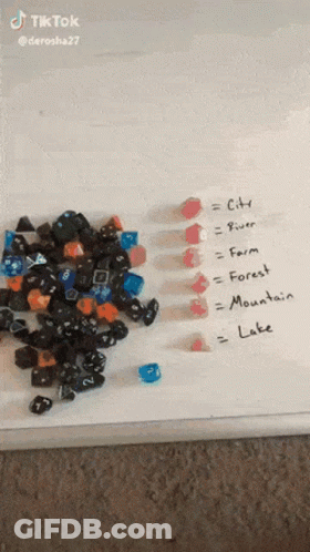 A Pile Of Dice Is Sitting On A White Board With The Words City River Farm Forest Mountain Lake Written On It . GIF