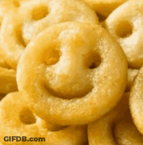 A Pile Of French Fries With Smiley Faces On Them GIF