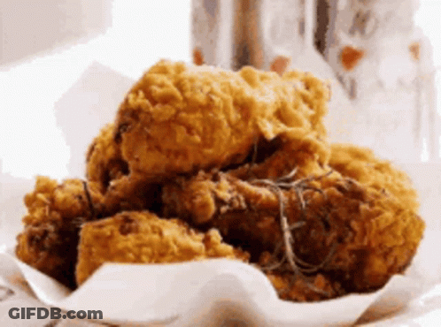 A Pile Of Fried Chicken Sitting On Top Of A Piece Of Paper GIF