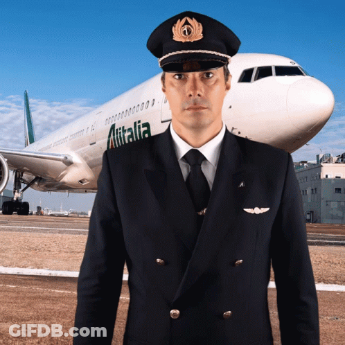 A Pilot Is Standing In Front Of An Airplane That Says Alitalia GIF