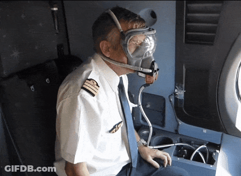 A Pilot Is Wearing A Gas Mask And Goggles While Sitting On An Airplane GIF