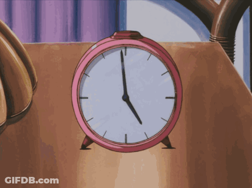 A Pink Alarm Clock On A Table Shows The Time As 5:00 GIF