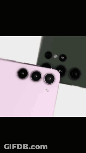 A Pink And A Green Cell Phone Are Sitting On Top Of Each Other On A Table . GIF