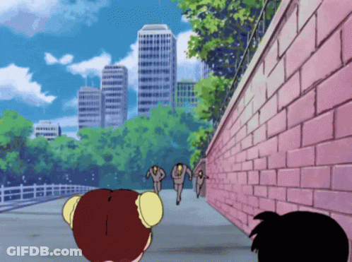 A Pink Brick Wall Is Surrounded By Trees And Buildings In The Background GIF