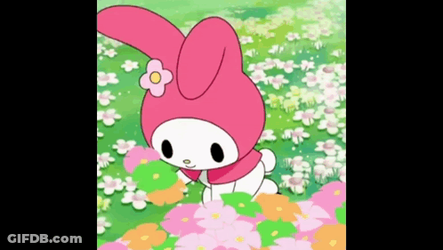 A Pink Bunny Rabbit With A Flower On Her Head Is Standing In A Field Of Flowers . GIF
