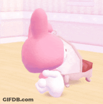 A Pink Bunny With A White Bow On Its Head Is Laying On A Table GIF