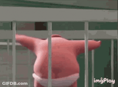 A Pink Cartoon Character Is Standing In A Cage . GIF