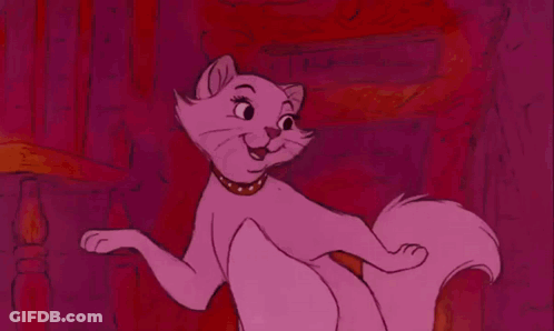 A Pink Cat Wearing A Gold Collar Is Sitting On A Pink Background . GIF