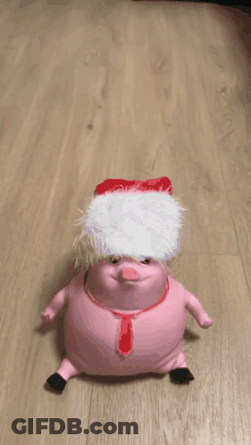 A Pink Stuffed Animal Is Crawling On A Wood Floor GIF