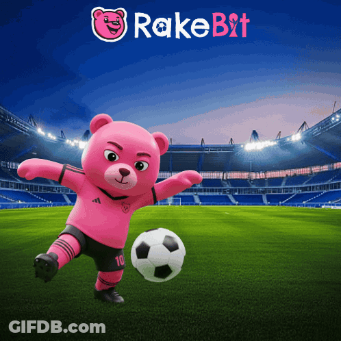 A Pink Teddy Bear Is Kicking A Soccer Ball On A Soccer Field With Rakebit In The Background GIF
