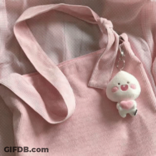A Pink Tote Bag With A Peach Keychain Attached GIF