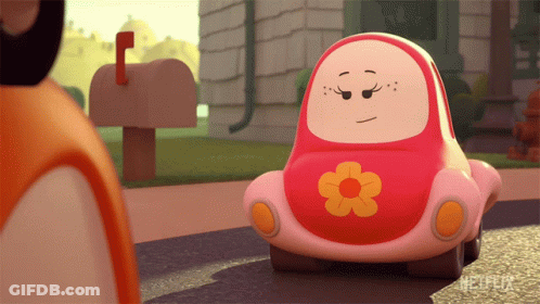 A Pink Toy Car With A Flower On The Front Is Sitting On The Street GIF