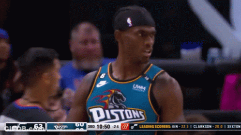 A Pistons Basketball Player Stands In Front Of The Scoreboard GIF