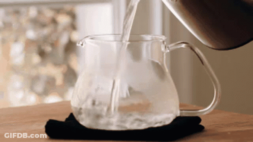 A Pitcher Of Water Is Being Poured Into A Cup GIF