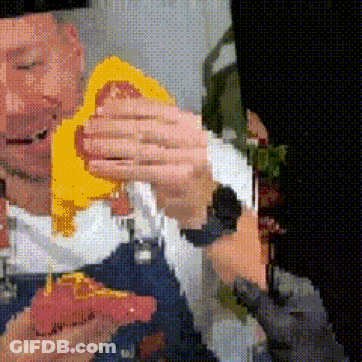 A Pixelated Image Of A Man Holding A Piece Of Pizza GIF