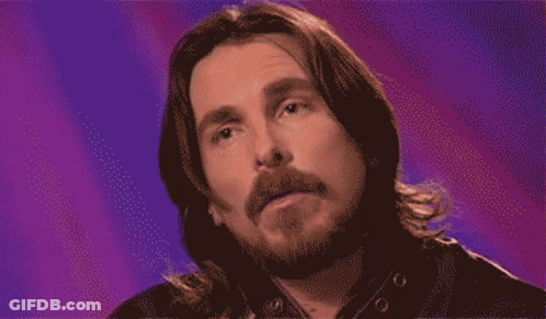 A Pixelated Image Of A Man With Long Hair And A Beard Against A Purple Background GIF